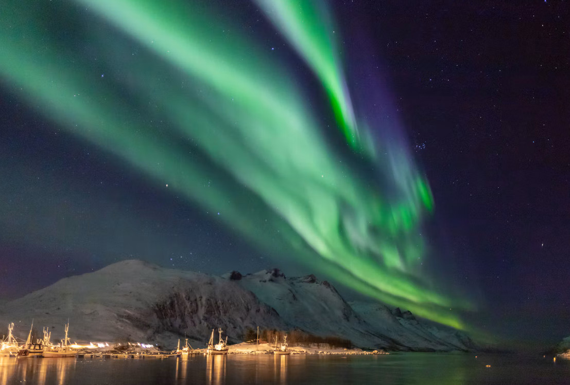 Northern Lights over a snowy Ersfjord landscape near Tromsø, Norway