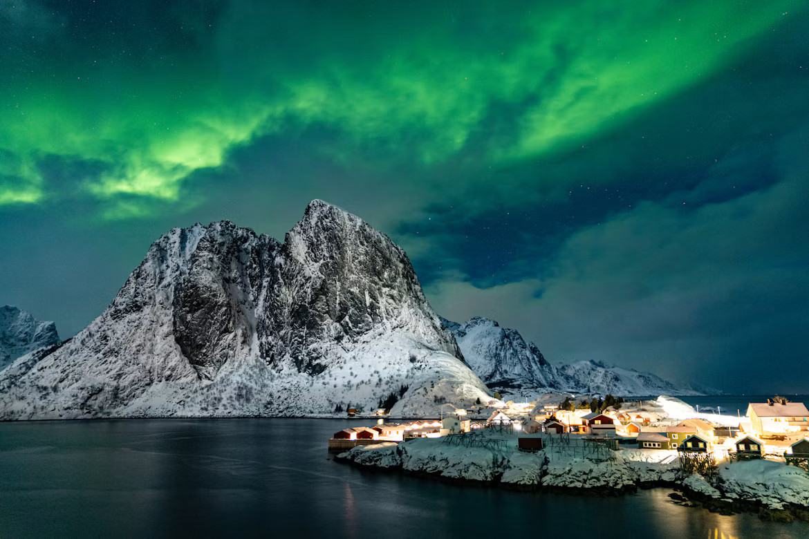 Natural Northern Lights above snowy Norwegian mountains and a fjord